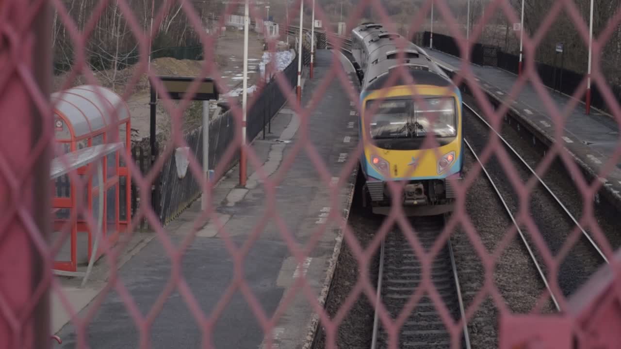 View from bridge of train leaving empty railway station