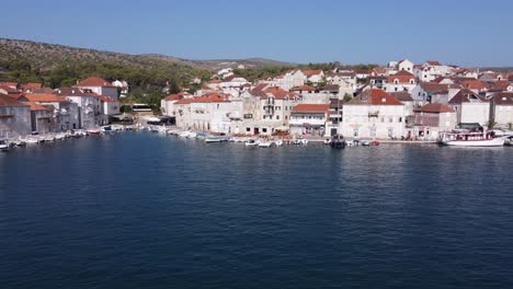 Casas-De-Piedra-Caliza-De-Dos-Pisos-A-Lo-Largo-De-Los-Muelles-Del-Puerto-Protegido-En-La-Ciudad-De-Milna,-Isla-De-Brac