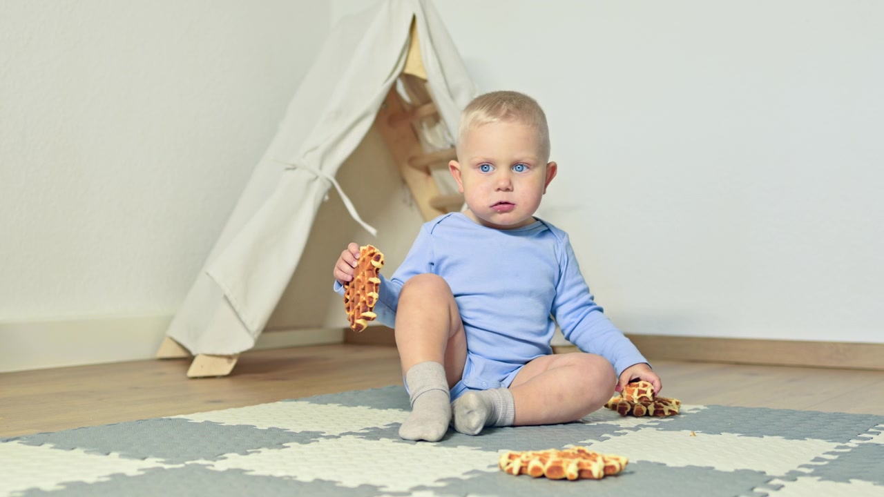 Kind genießt Snack, während es im Spielzimmer auf dem Boden sitzt, mit einem Zelt im Hintergrund, während der Spielzeit am Nachmittag