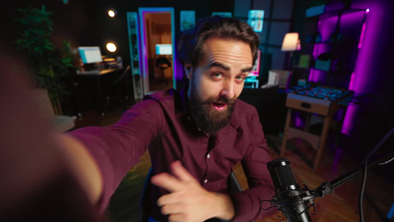 una foto de un influyente alegre grabándose a sí mismo saludando a los fans.