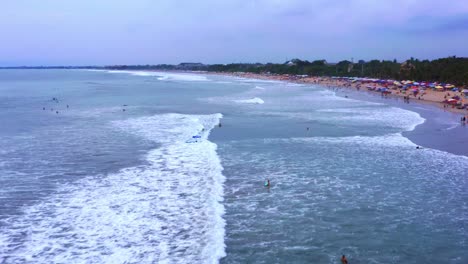 Menschen-Schwimmen-Am-Strand-Mit-Schäumenden-Wellen-In-Kuta,-Indonesien