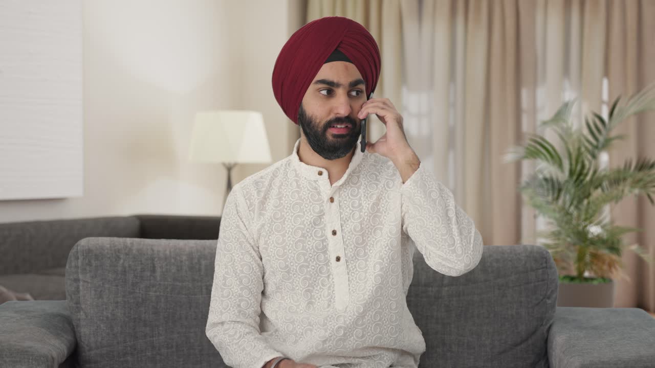Uomo indiano Sikh che parla al telefono.