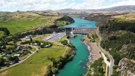 Río-Azul-De-Nueva-Zelanda-Con-Pequeña-Ciudad-Y-Presa-De-Hormigón,-Vista-Aérea