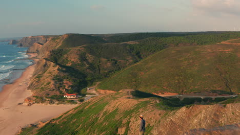 antena: un hombre parado en un mirador mirando a los surfistas en portugal