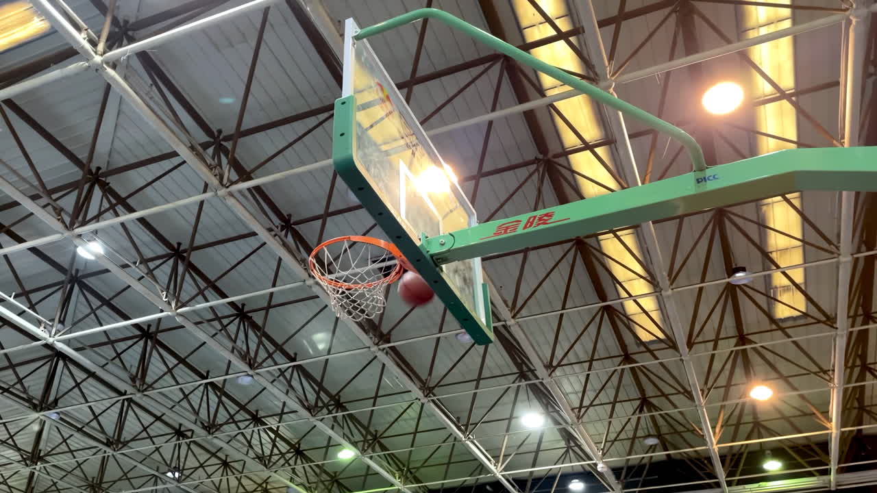 pelota de baloncesto pasando por la red del aro, y la cancha en el parque para el juego al aire libre, tiro o punto de anotación en el aro o partido