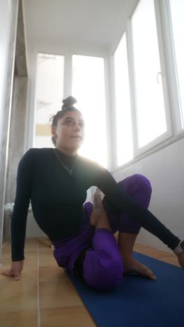 young woman practicing yoga on a balcony