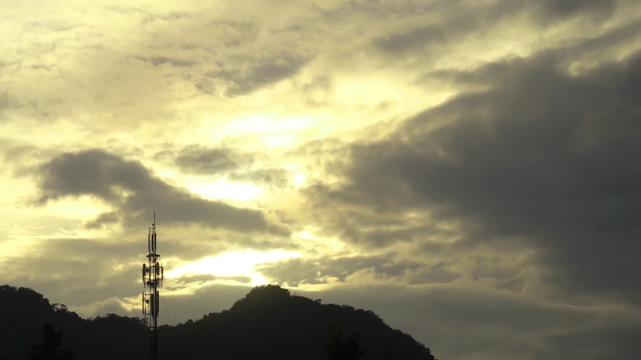 Black stormy cloud on Sunset golden yellow sky n communication antenna