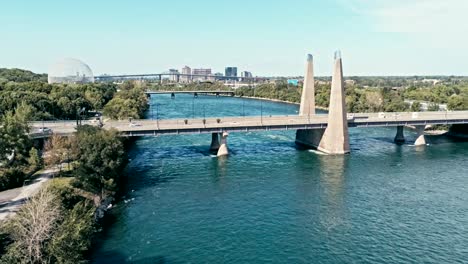 aerial drone footage of montreal with bridges and a park area plus ile sainte helene island with the biosphere dome in the background