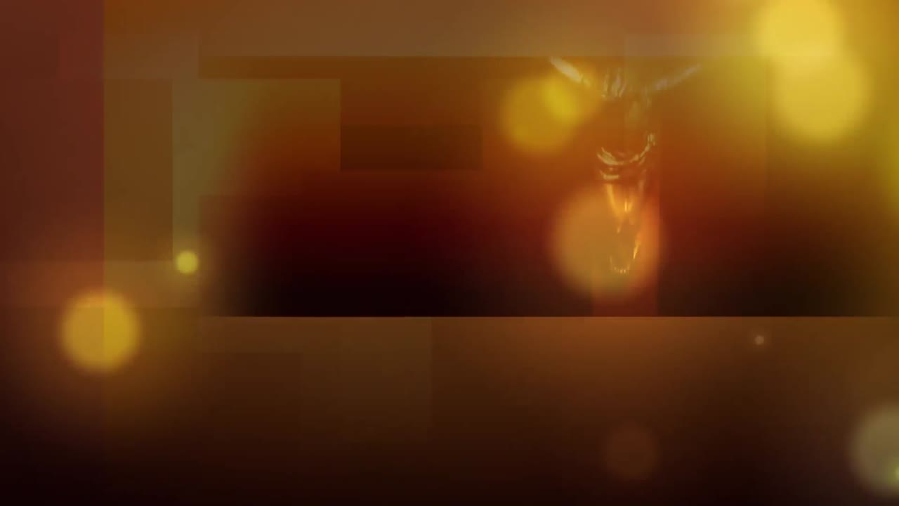 Video generado digitalmente de puntos luminosos naranjas moviéndose sobre una vela encendida de fondo.