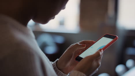 close up of womans hands using smart phone to read business graphs