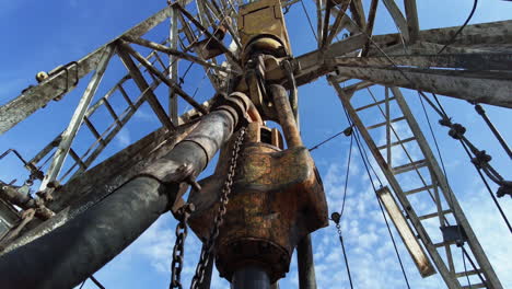 spinning borer drilling natural resources. low angle view at the derrick producing oil.