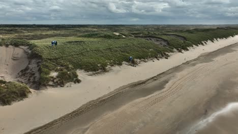 kiteboarding en una playa con dunas de arena