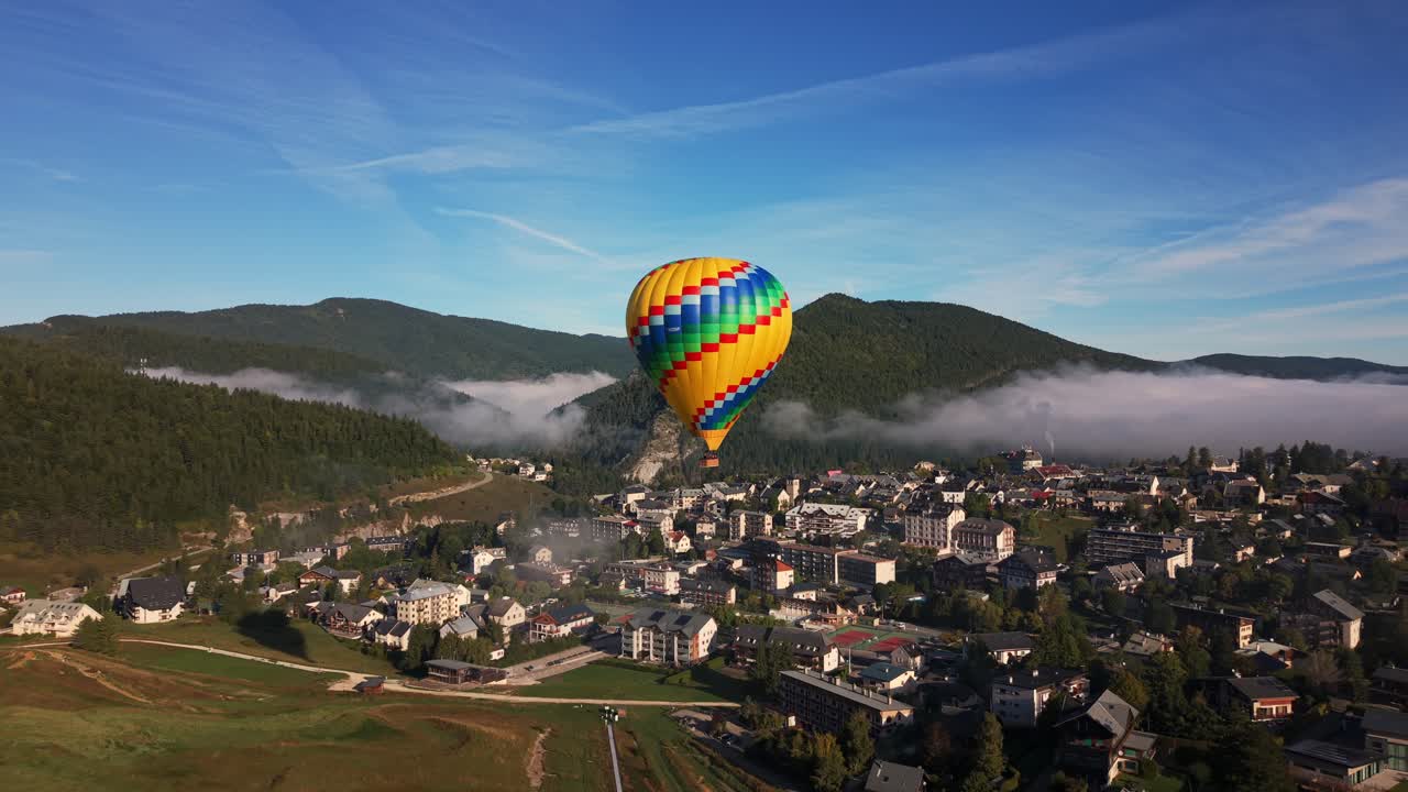 Turismo de aventura nos Ródano-Alpes, França, mostrando uma vista aérea de um balão de ar quente voando