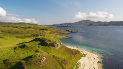 wide rotating drone shot of coral beach in claigan with white sandy beaches and tropical blue water, in scotland