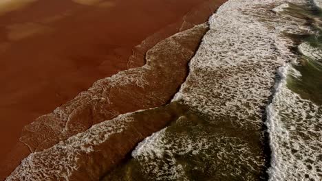 gentle atlantic ocean waves run out onto golden sandy beach