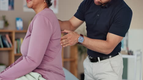 physical therapist examining patient's back