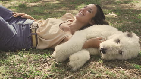 young woman pets a big dog lying on the grass