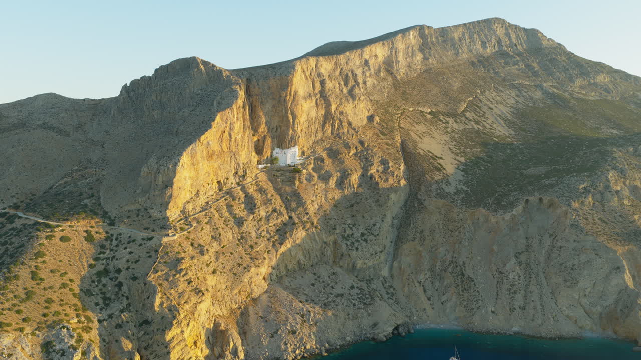 Historic Greek Orthodox Monastery Embedded in Golden Cliffs of Amorgos Island at Sunrise, Greece