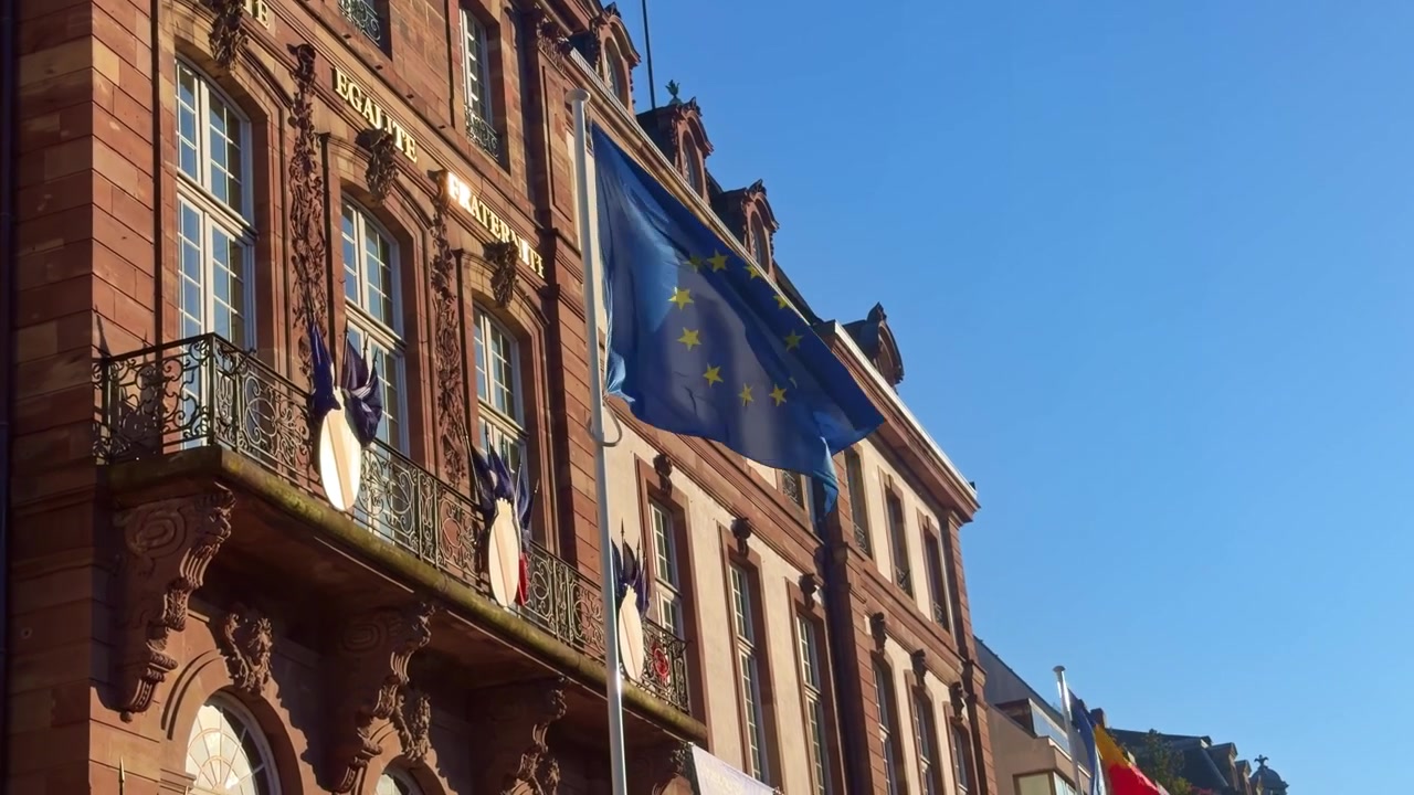 EU-flagg og moldovsk flagg vaier i vinden på rådhusfasaden i Strasbourg, Frankrike