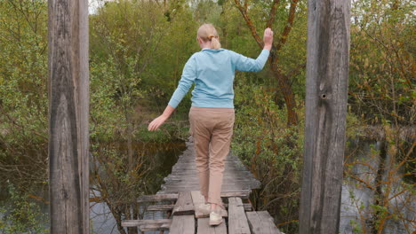 woman walking on a wooden bridge over a river