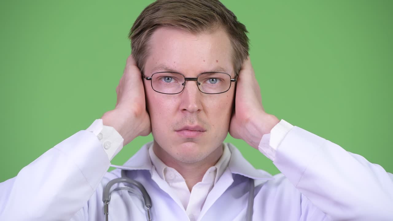 Portrait Of Young Man Doctor Covering Ears