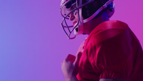 Video-of-caucasian-american-football-player-in-helmet-over-neon-purple-background