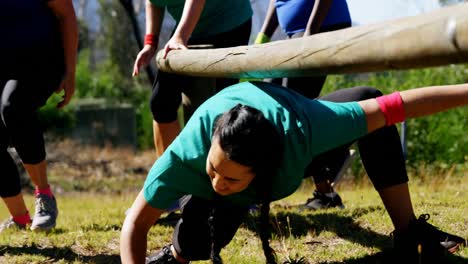 Trainer-assisting-women-in-during-obstacle-course