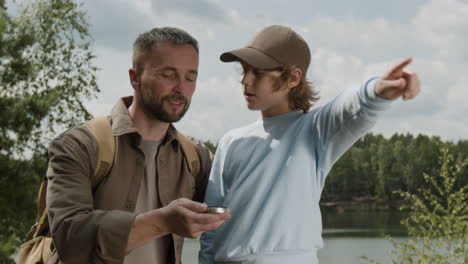 father and son exploring nature with compass
