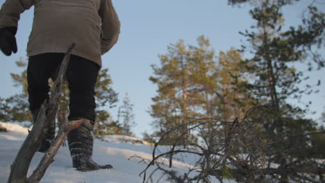 Tired-Exhausted-Man-Walking-Through-Snowy-Winter-Forest,-Low-Angle,Slowmo