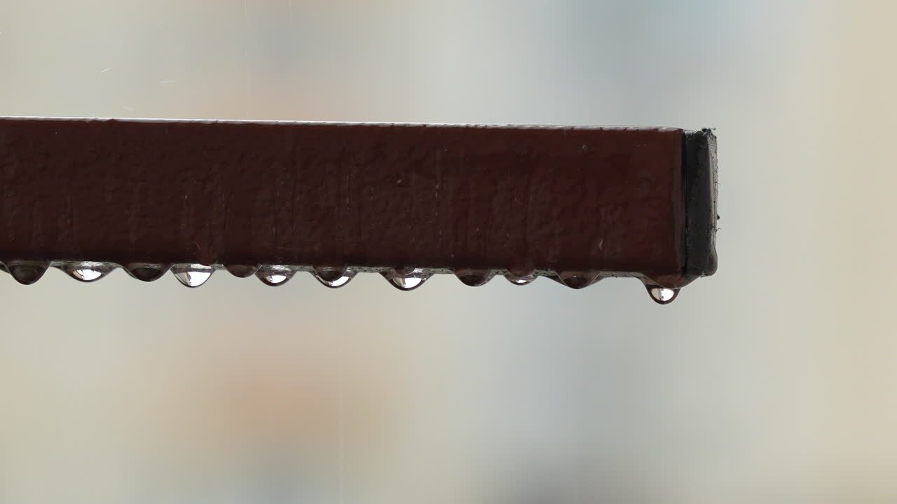 금속 레일링에서 떨어지는 물방울 또는 물방울 - 클로즈업 슬로우 모션