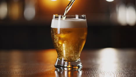 pouring beer into glass at a bar