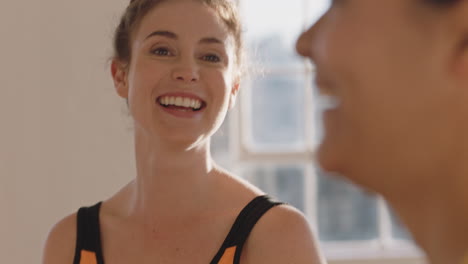 portrait beautiful young caucasian woman chatting to friend in yoga class discussing healthy fitness lifestyle sharing training tips enjoying conversation in studio
