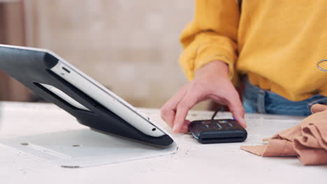 Close-Up-Of-Sales-Assistant-Taking-Credit-Card-Payment-In-Clothing-Store