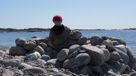 boy playing on stone beach