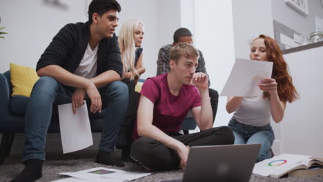 grupo de estudiantes universitarios en una habitación de casa compartida estudiando juntos