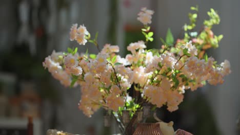 a vase with beautiful peach-colored flowers on the table