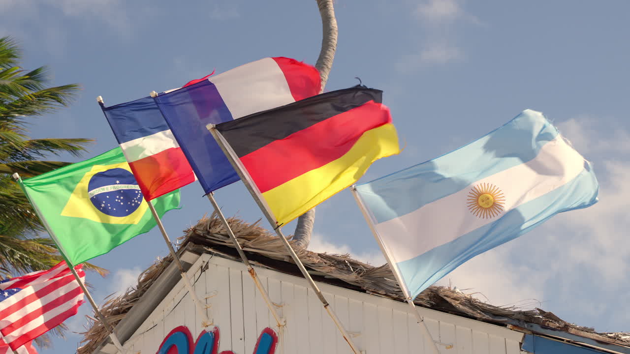 National Flags Of Countries Waving In Air Attached To Beach Shopping Building At Punta Cana In Dominican Republic