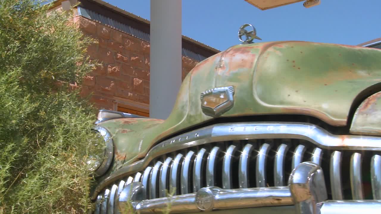 버려진 교역소 2에서 오래된 녹슨 차를 따라 천천히 움직이는 샷 추적