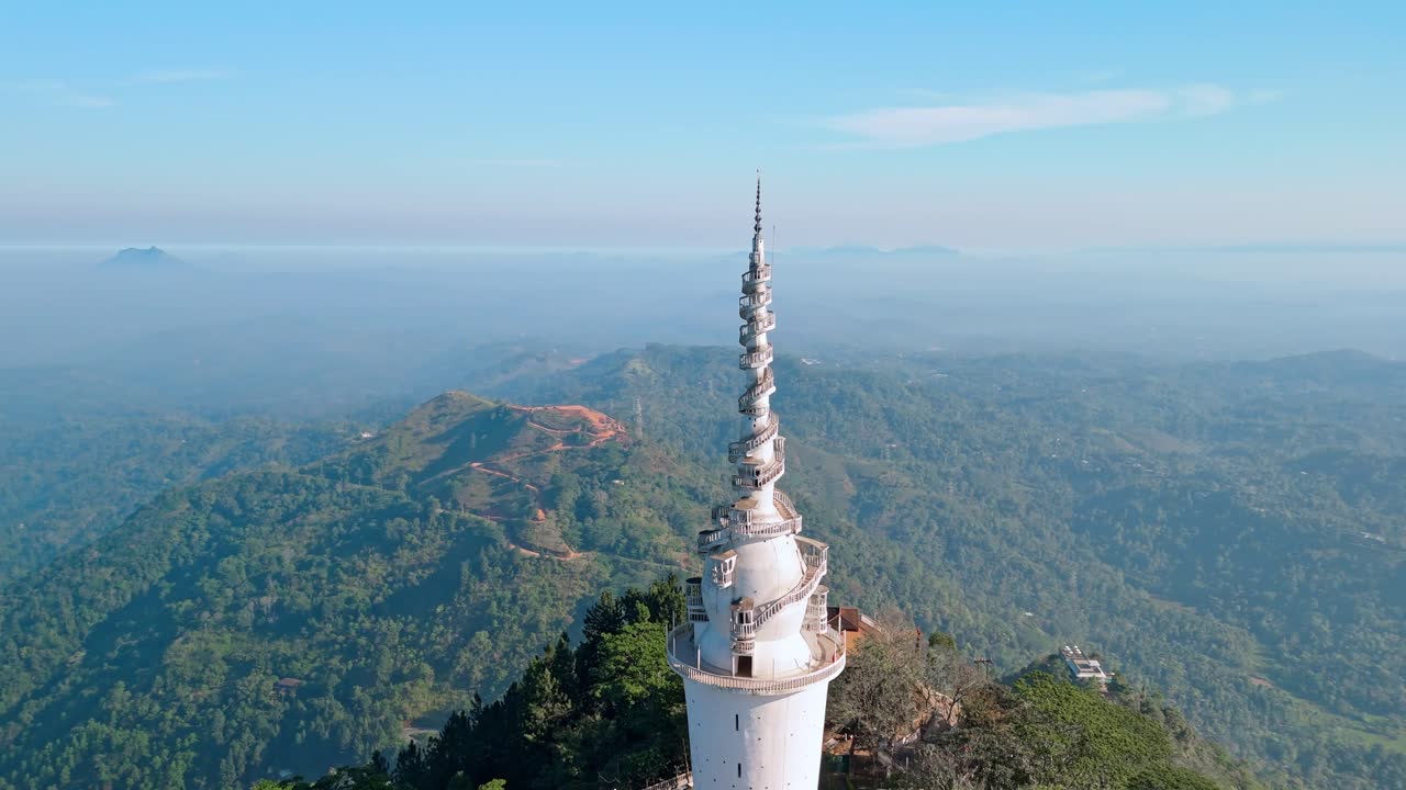Experience the grandeur of Ambuluwawa Tower close to Kandy city at sunrise, captured from a drone (orbit shot).