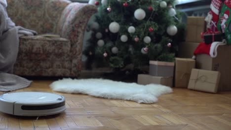 robotic vacuum cleaner hoovering the floor at christmas