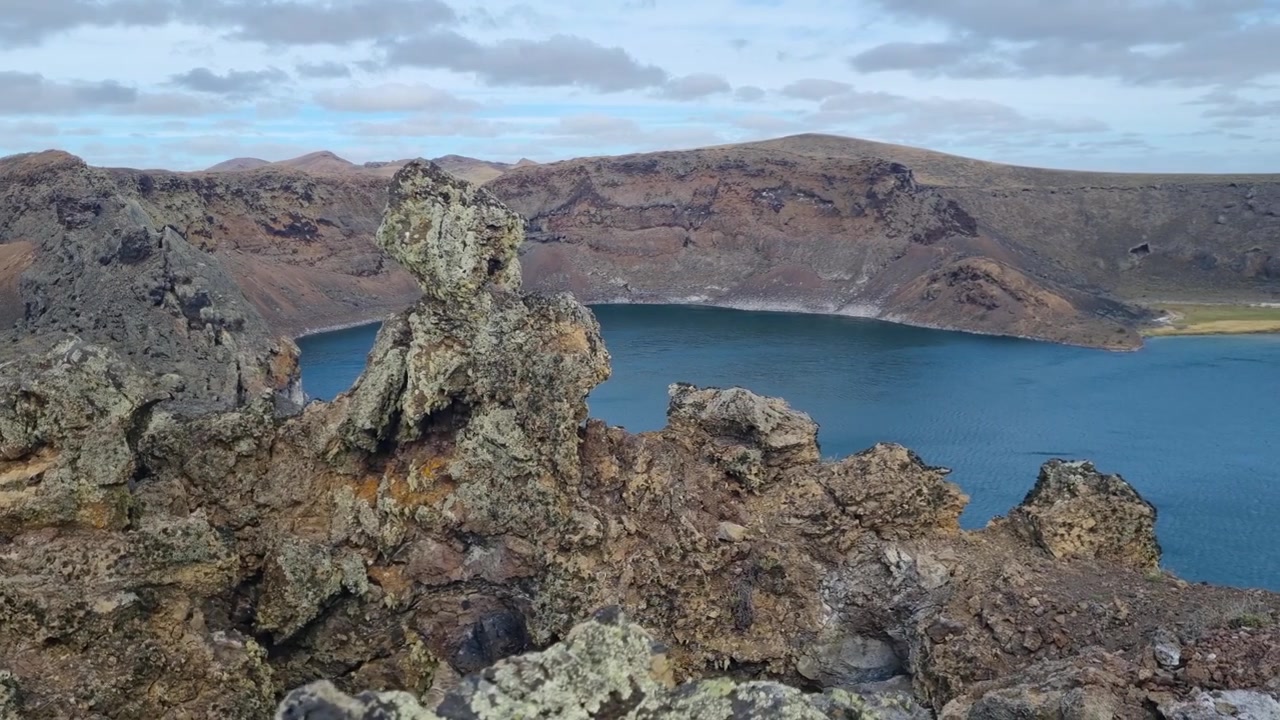 Syvän siniset vedet täyttävät Laguna Azulin, tulivuoren kraatterijärven Pali Aike -tulivuorialueella lähellä Río Gallegosia, Argentiinassa, esitellen karuja Patagonian maisemia ja koskematonta erämaata.