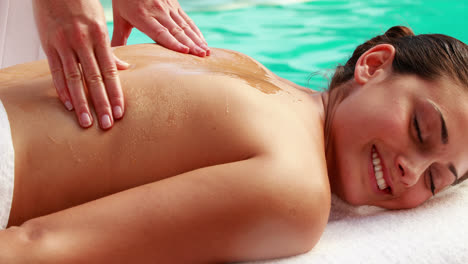 terapeuta de belleza masajeando aceite en la espalda de la mujer