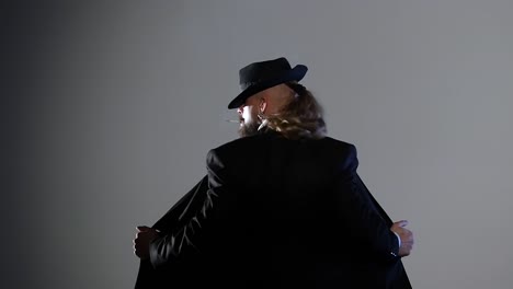 man in hat and jacket smoking