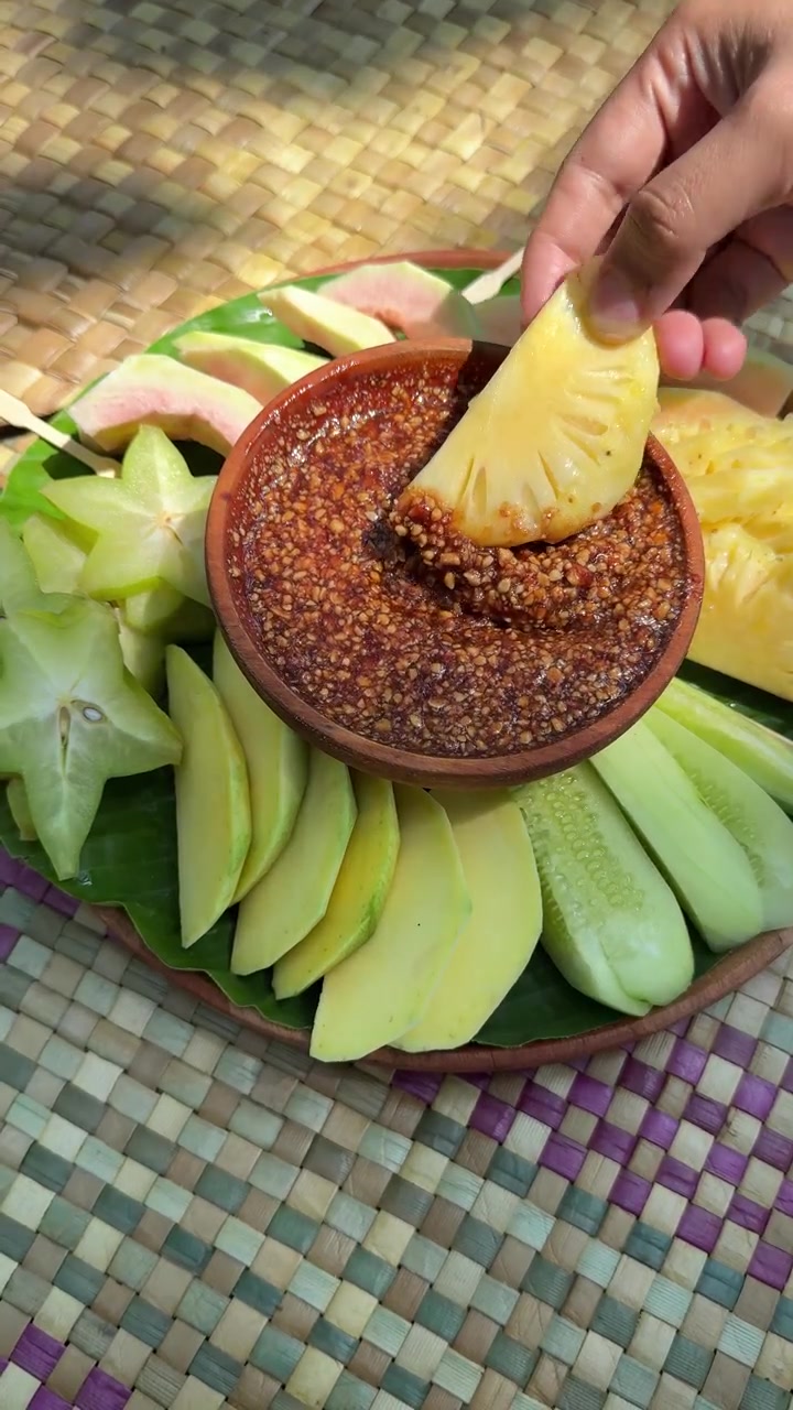 Fetta di ananas fresco immersa a mano nella salsa chili piccante