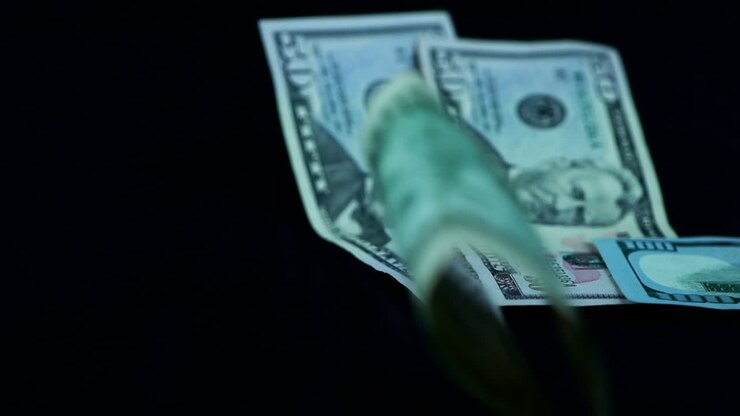 Primo piano di banconote da dollaro che cadono, scatto in studio.