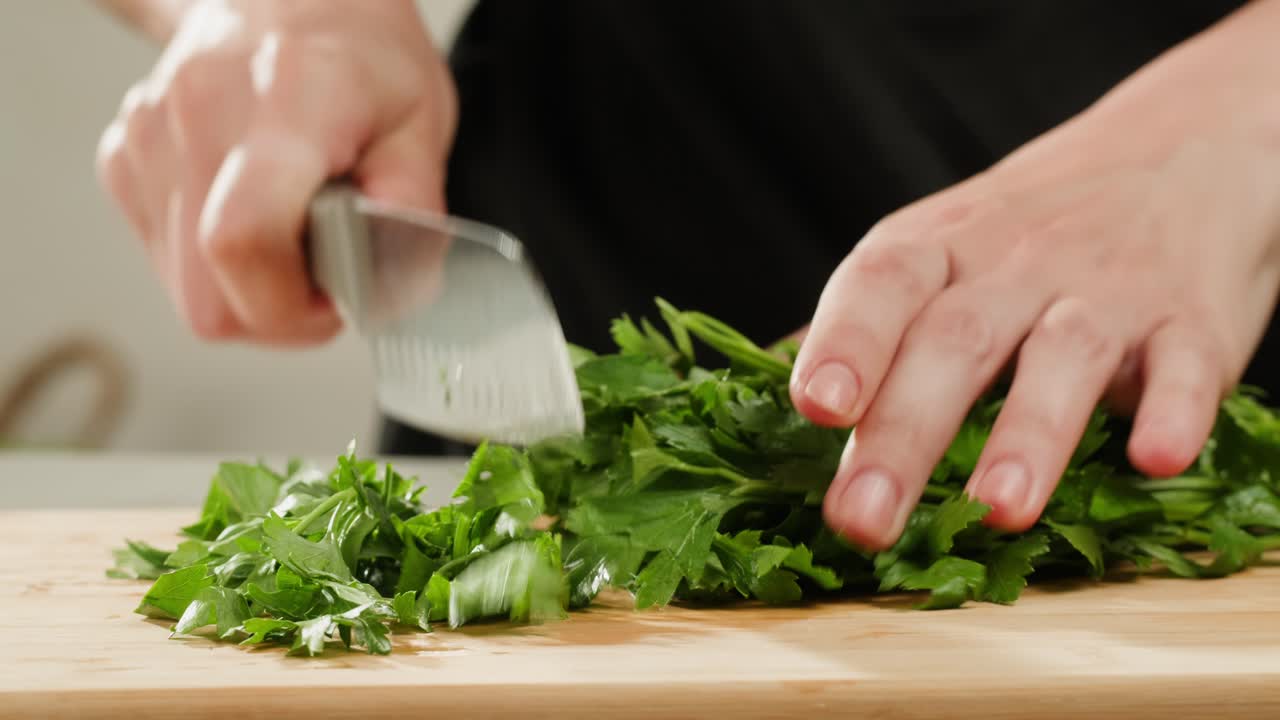 Cilantro parsley cutting by knife close up, chef chop cut coriander aromatic, traditional asian and Mexican cuisine herb studio shot. High quality 4k footage