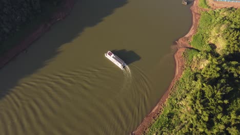 Barco-Turístico-Dando-La-Vuelta-Al-Río-Iguazú-Al-Atardecer,-Frontera-Entre-Argentina-Y-Brasil