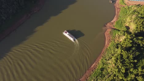 barco turístico dando la vuelta al río iguazú al atardecer, frontera entre argentina y brasil
