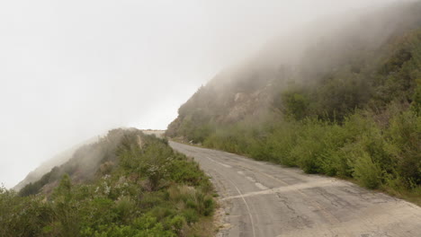 drone flying forward over an asphalt mountain road