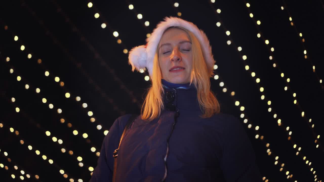 retrato de una mujer sonriendo a la cámara y jugando en un sombrero de santa
